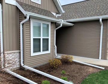 completed installation of new white gutters on a residential home
